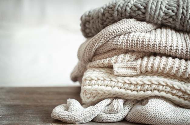 close-up-neatly-folded-knitted-items-pastel-color_169016-7137