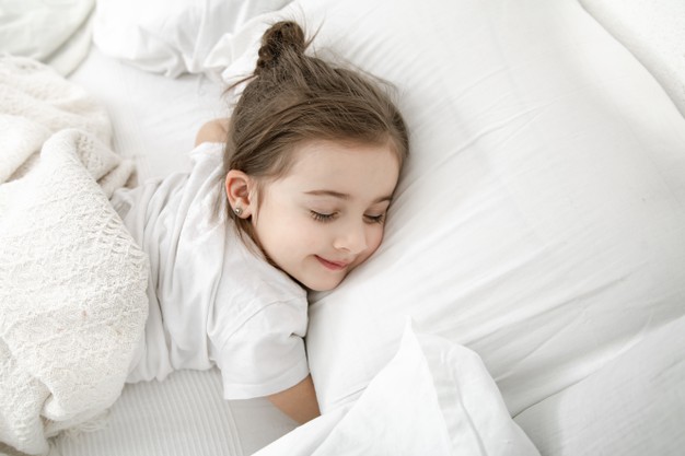 cute-little-girl-is-sleeping-white-bed_169016-6449