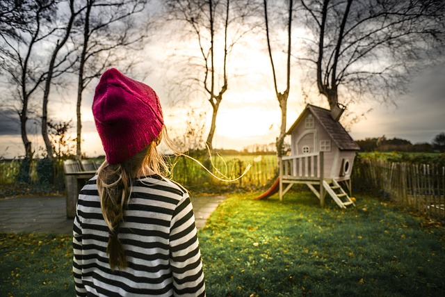 Dievčatko v čiapke sa pozerá na malý domček.jpg